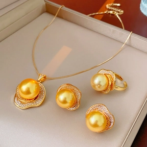 Detail of golden jewelry set with large pearls and sparkling zircons in a box