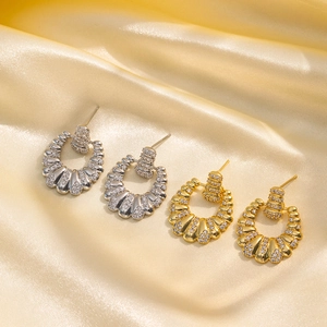 Textured gold and silver hoop earrings with inset crystals on elegant satin background