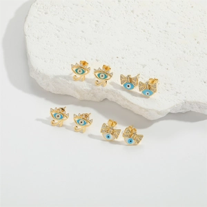 Detailed close-up of evil eye stud earrings with blue enamel on white stone base