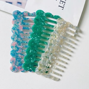 Three acetate hair combs with elegant marble patterns in blue, green, and beige colors