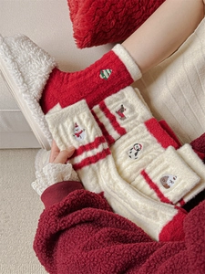 Close-up of thick plush Christmas socks with festive snowman and reindeer embroidery
