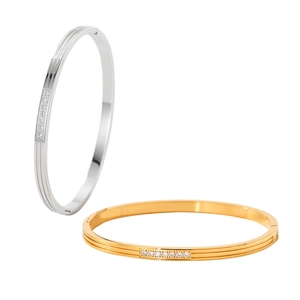 Detail of 18K gold and silver titanium steel bangles with grooved texture and inset diamonds