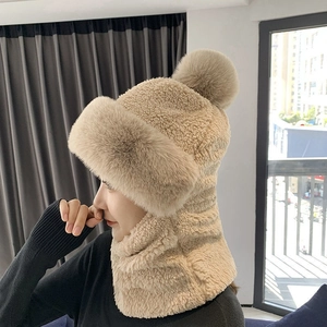 Beige winter sherpa hooded scarf with ear flaps and fur trim worn by a female model