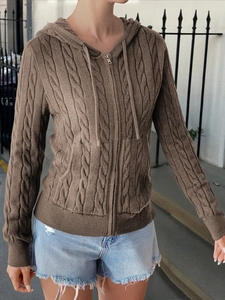 Close-up of brown cable-knit hooded cardigan with metal zipper and drawstring details
