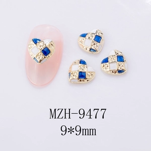 Macro detail of 9x9mm blue and white checkerboard heart nail art charms with gold trim