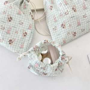 Detail of cartoon quilted drawstring pouch with bunny and bear patterns for cosmetics