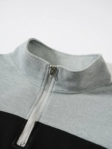 Détail du pull gaufré gris et noir avec col à demi-fermeture éclair et zip métallique