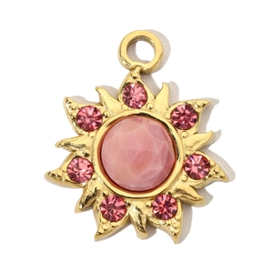 Macro view of gold sun pendant with pink natural stone and sparkling rhinestones