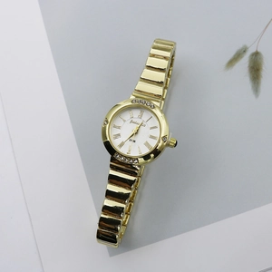 Detailed macro view of the gold quartz watch featuring Roman numerals and crystal accents
