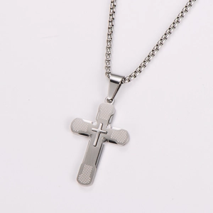 Detailed view of a silver stainless steel cross pendant with mesh texture and smooth finish