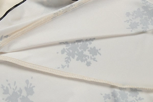 Detailed macro view of high-quality stitching and light blue floral print on beige fabric