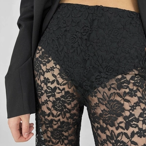 Dettaglio ravvicinato dei pantaloni in pizzo floreale trasparente a vita alta neri