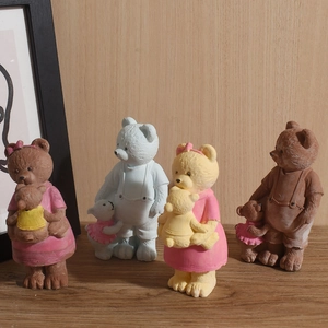 Detail of multi-colored bear family figurines with matte texture on a wooden surface