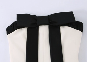 Détail du grand nœud noir sur le haut bustier contrasté avec texture de tissu fine