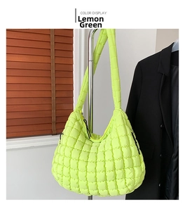 Detail of lime green quilted puffy shoulder bag with puffer style fabric and strap