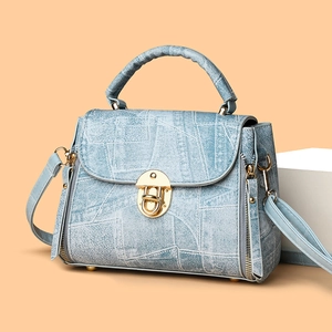Light blue denim texture handbag with gold metal twist lock and adjustable strap