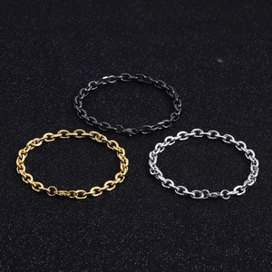Detailed close-up of three Cuban and Figaro chain bracelets in black, gold, and silver steel