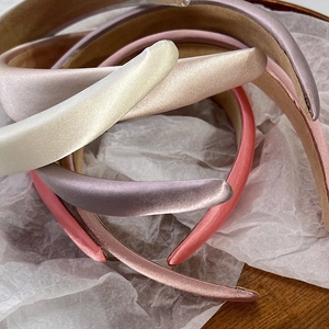 Macro shot of satin padded headbands showing smooth silk texture and Morandi colors