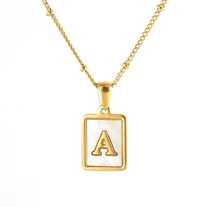 Detailed close-up of golden square necklace with white shell inlay and A initial letter