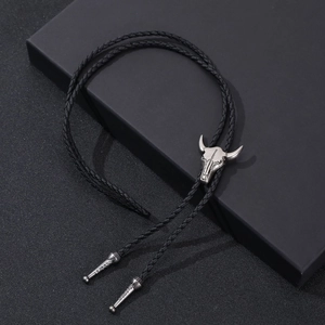 Vintage western bolo tie featuring a silver bull head pendant and black braided leather cord