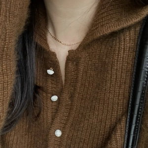 Minimalist 925 sterling silver gold plated necklace on brown knit cardigan