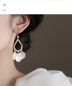 Gros plan sur des boucles d'oreilles élégantes en nacre et zircons portées par un mannequin