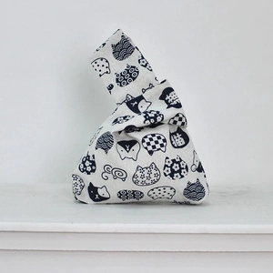 Detail of Japanese knot wrist bag featuring cotton linen fabric and cat patterns