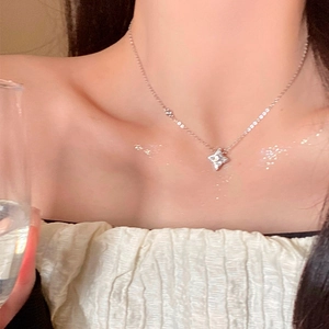 Elegant silver four-point star pendant necklace with sparkling diamonds on a model