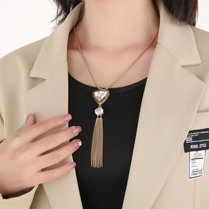 Close-up of golden tassel necklace with triangle crystal pendant on a female model