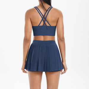 Rear view of navy blue pleated tennis skirt and cross-strap sports bra yoga set