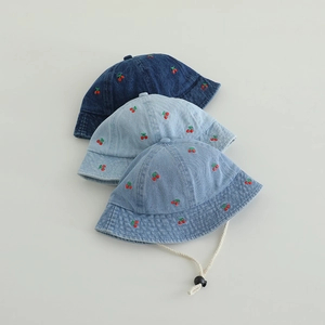 Detailed view of baby denim bucket hats with cherry embroidery in three blue washes