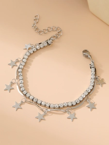 Macro shot of silver double-layered bracelet with crystal stars and cross pendants