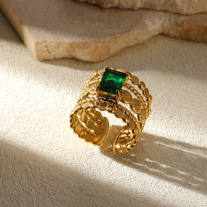Macro shot of gold hollow leaf ring featuring a square emerald and adjustable band