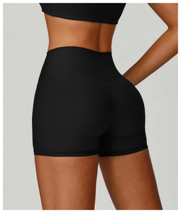 Macro shot of high-waist black ribbed yoga shorts showing fabric texture and tummy control