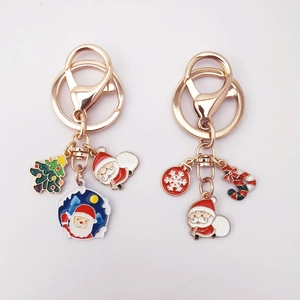 Christmas enamel keychains set with Santa Claus and tree charms on white background