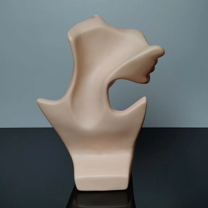 Detail of minimalist skin-tone mannequin stand for displaying necklaces and jewelry