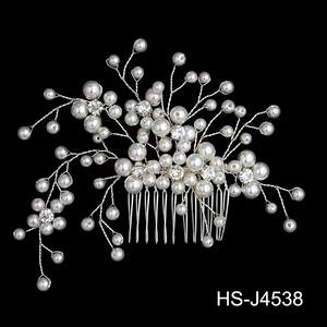Detail of silver bridal hair comb with white pearls and sparkling crystal flowers