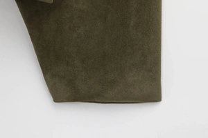 Macro detail of military green faux suede bomber jacket showing soft matte texture