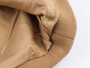 Macro shot of camel wool coat interior featuring high-quality striped silk texture lining