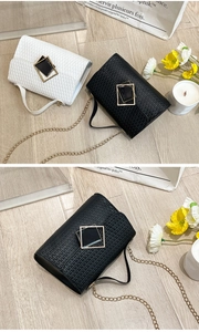 Detalle de bolsos bandolera con textura trenzada en blanco y negro con cadenas de oro