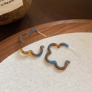 Detail of flower-shaped resin hoop earrings in vintage tortoiseshell and blue gradient