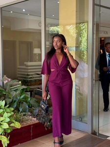 Deep V-neck jumpsuit in purple with waist cut-outs and elegant flared sleeves