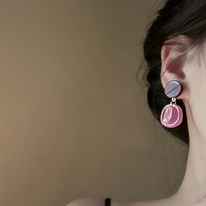 Detail of silver needle resin drop earrings in purple and pink on a female model