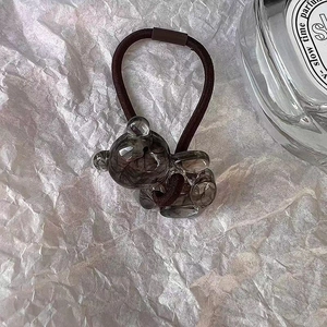 Détail d'un mignon pendentif ours en acétate sur un élastique à cheveux marron