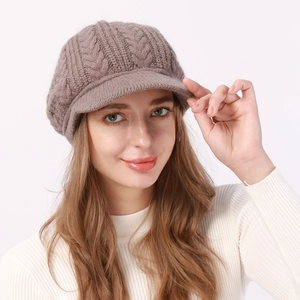 Detalle de la boina de punto trenzado topo con visera y textura cálida de invierno