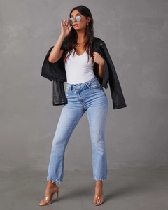 Dettaglio della vita incrociata e dell'orlo sfrangiato sui jeans in denim azzurro chiaro