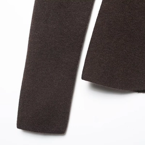 Detail of dark brown knit blazer sleeve showing premium compact texture and fine stitching