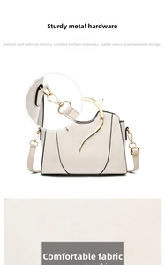 Detail of white leather handbag with unique gold cat-ear handles and metal hardware