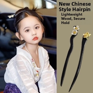 Close-up of handmade wooden hairpins featuring white plum and golden lotus flower detail