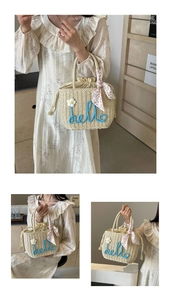 Detail of hand-woven straw bag featuring hello text, daisy flower and floral scarf